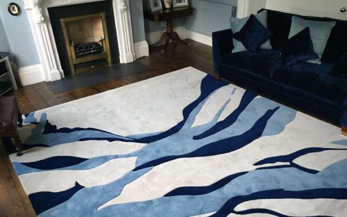 Hand tufted cream rug with blue splashes