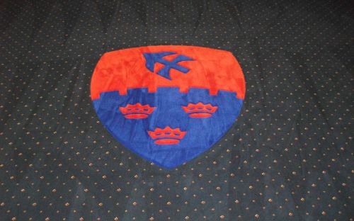 Hand tufted crest inset into carpet