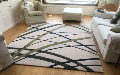 Hand tufted cream rug with shades of green crisscrossing it