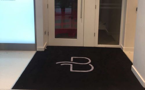 Hand tufted entrance rug with logo