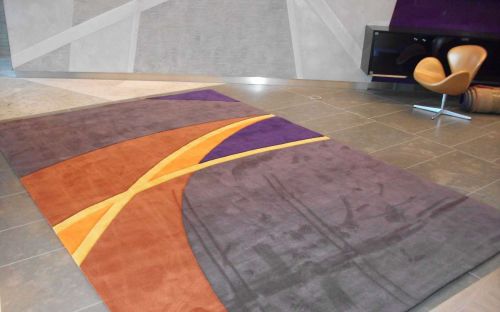 Hand tufted large purple rug with arcs of colour